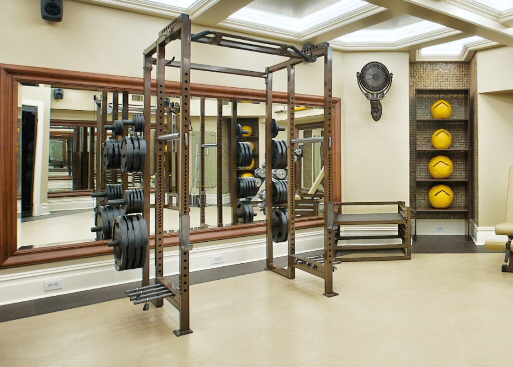 home gym with weights, power rack, band pegs, safeties, and medicine balls