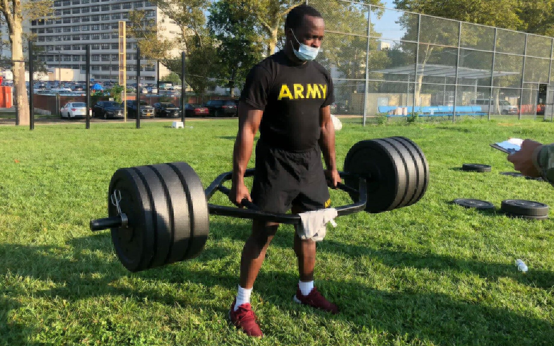 man from the national guard performing a trap bar deadlift on grass