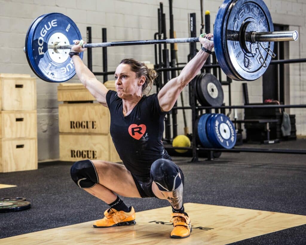 female lifter performing a snatch with a women's multipurpose bar