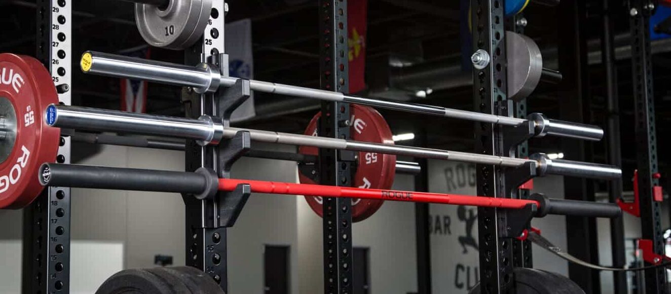 three barbells in a rack, two weightlifting bars and a power bar