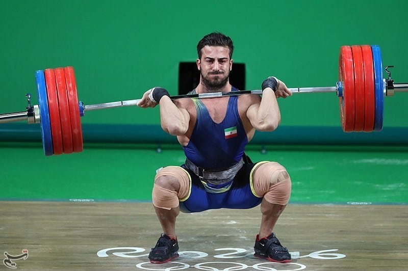 male weightlifter catching a clean with a weightlifting bar