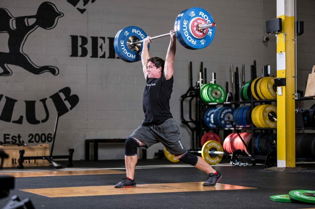 man doing a clean and jerk with multipurpose bar