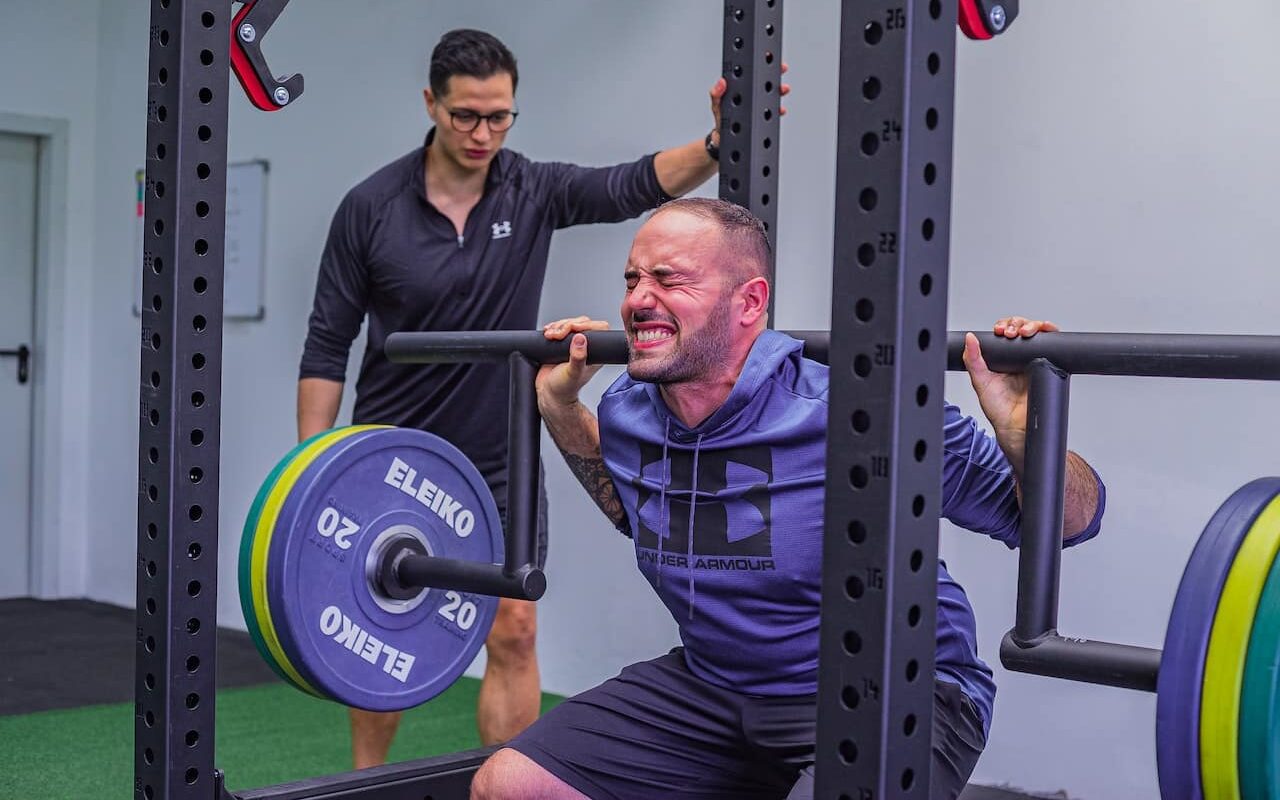 man squatting with a cambered squat bar