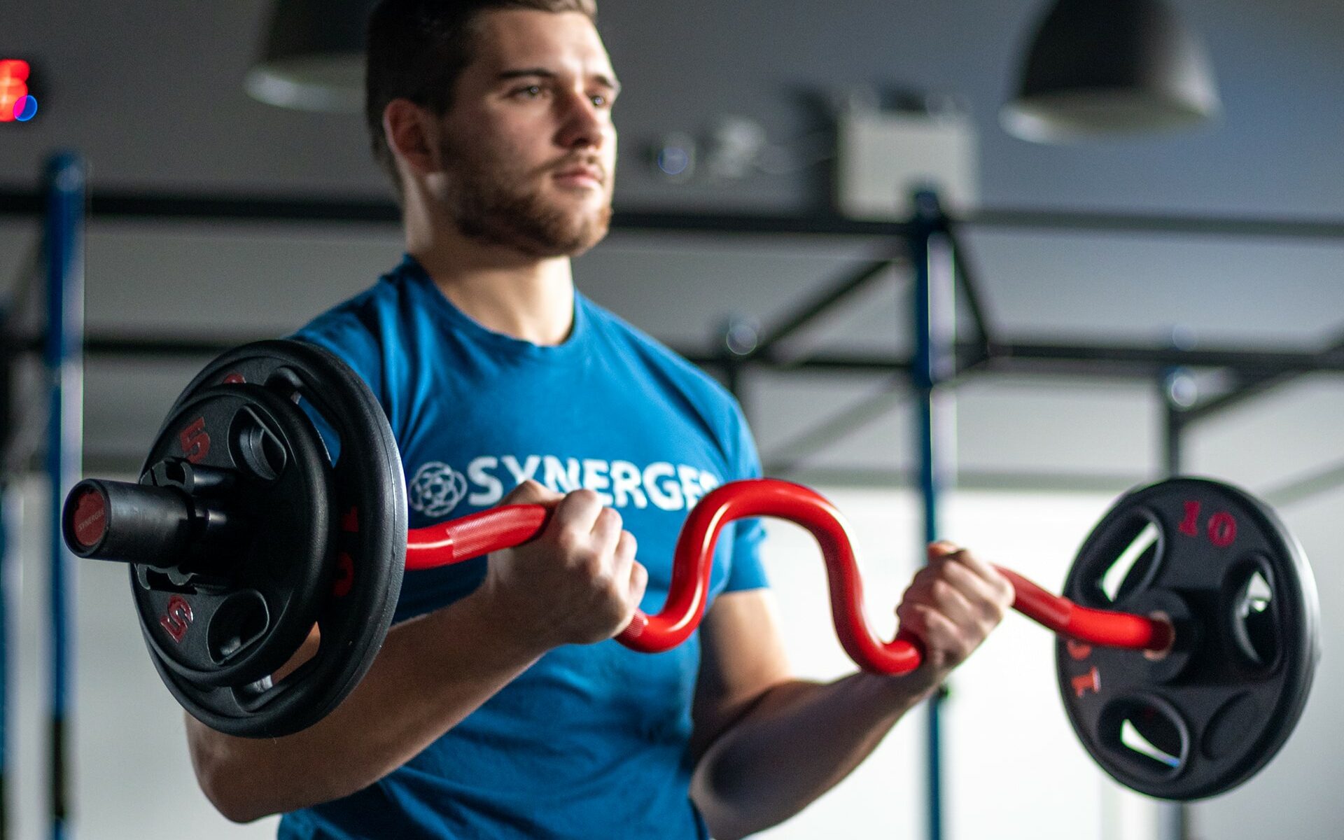 man doing curls with synergee super curl bar