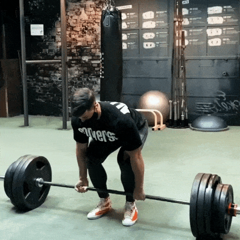 man doing conventional deadlifts with 415lbs of weight plates using a basic Olympic bar