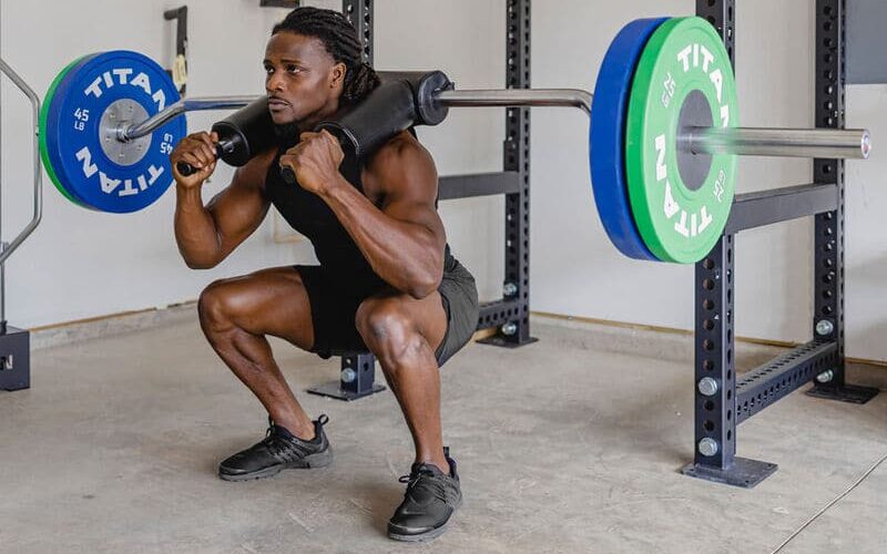 man lifting with the titan safety squat bar