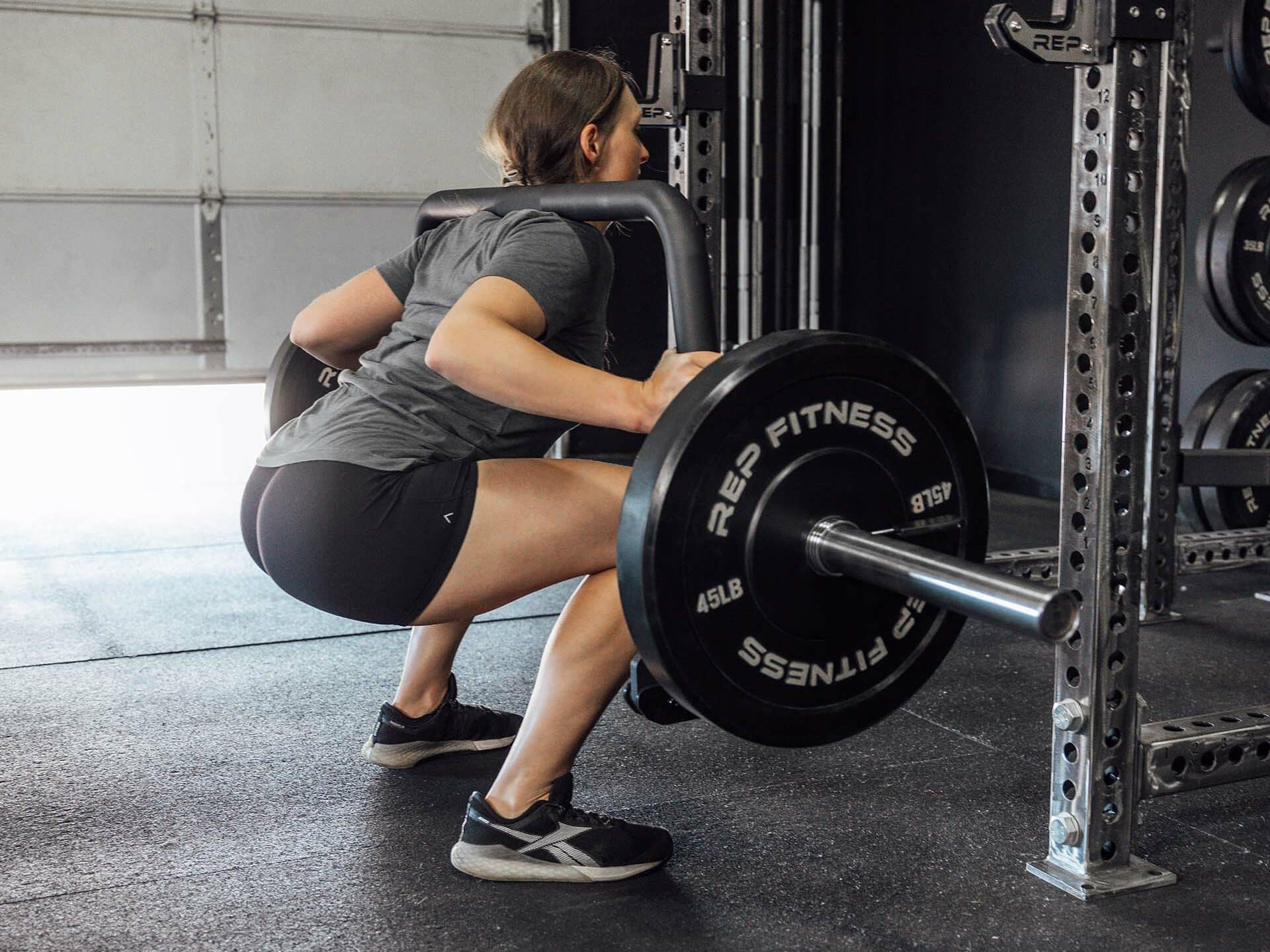 woman squatting with open trap bar