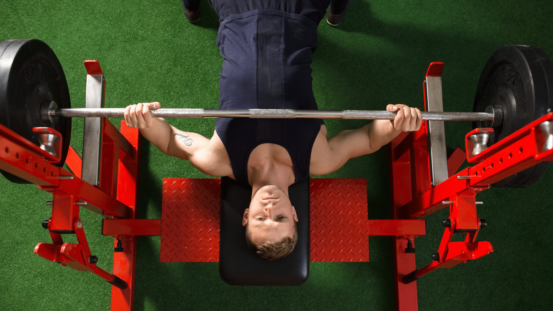 man doing the bench press with a straight bar