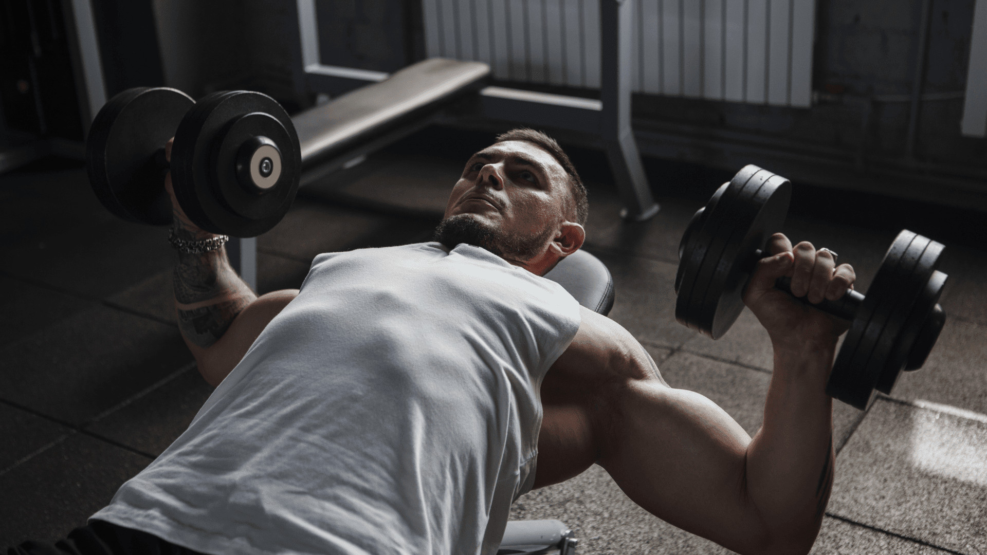 man doing a chest exercise with dumbbells