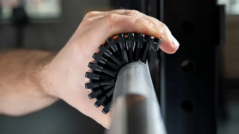 man cleaning barbell knurling with brush