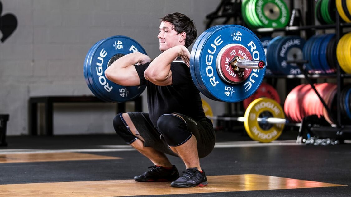 man squatting with ohio bar