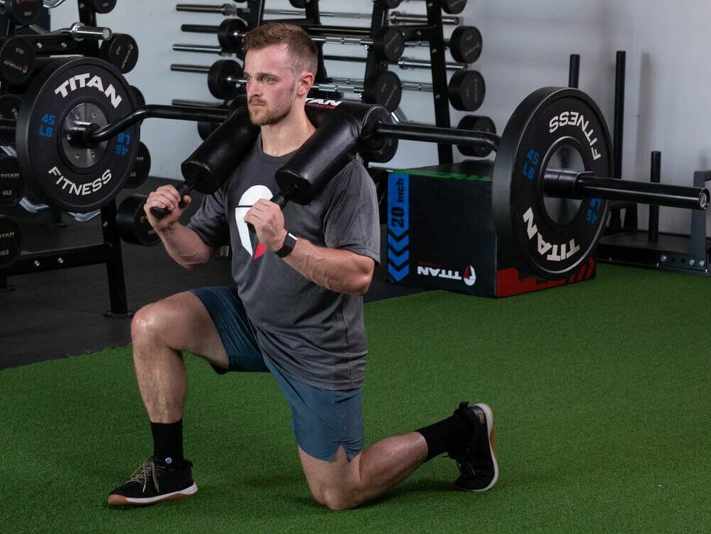 man doing safety squat bar lunges