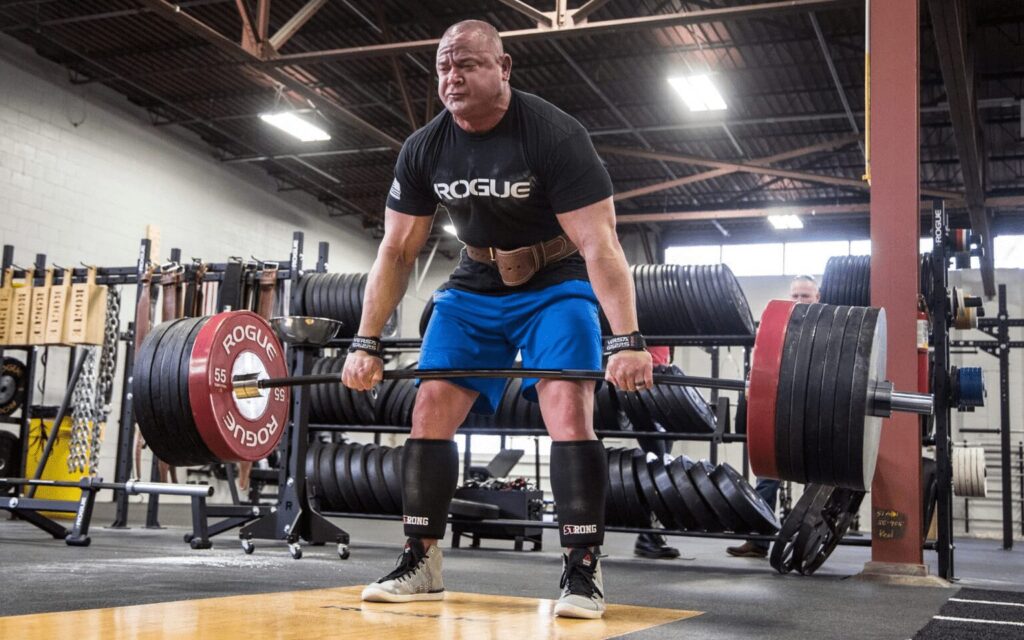 mark bell doing a deadlift using a deadlift bar