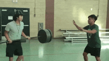 man handing off barbell and absolutely obliterating him